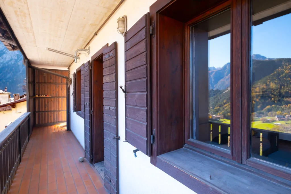 Covered balcony surrounding Mountain View Apartment with mountain panorama on three sides.